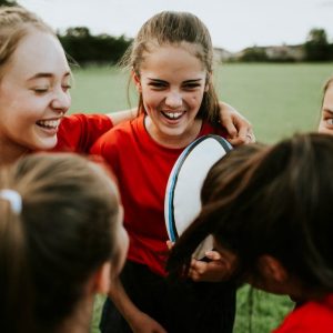 Cheerful girl&rsquo;s rugby team talking after the game